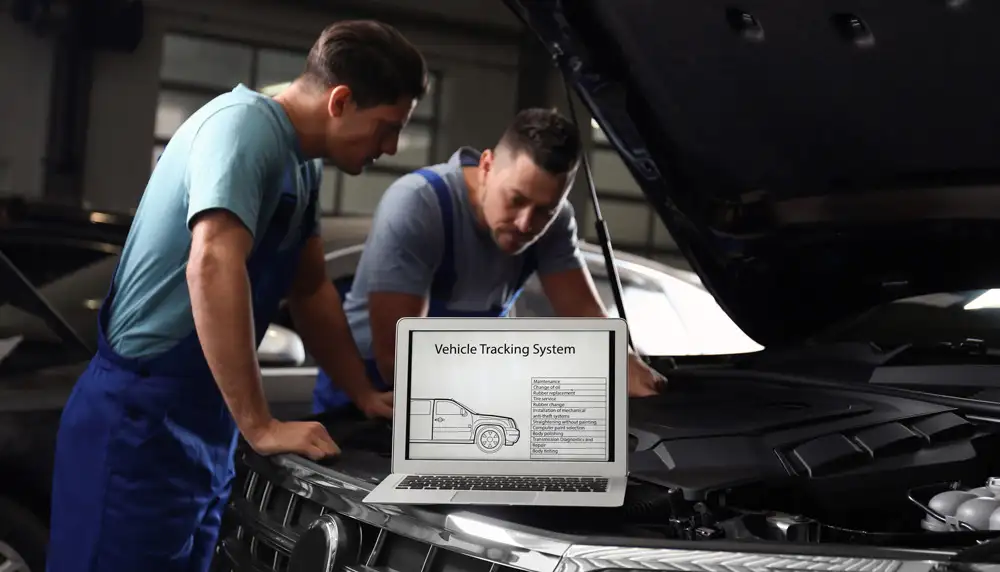 Kia mechanics looking at the engine of a Fleet GPS Tracked vehicle that is due for maintenance.