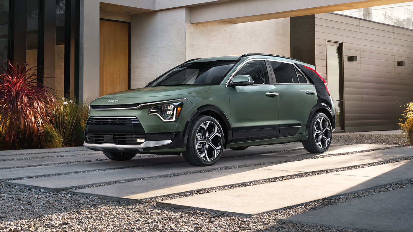 Vue de face de l’extérieur d’un Niro Hybride SX de couleur Vert urbain, équipé de jantes en alliage de 18 pouces.