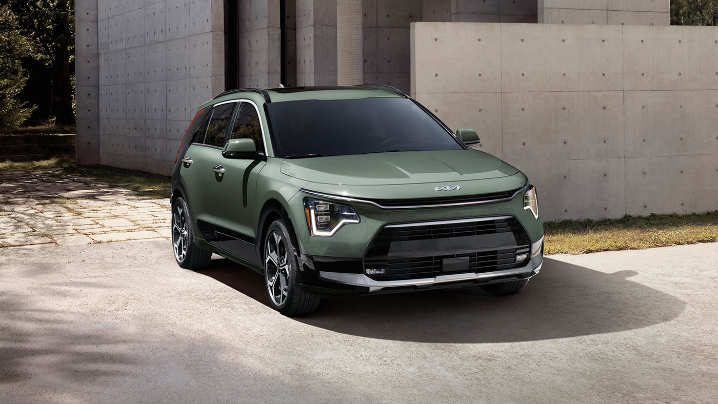 Vue de face de l'extérieur d’un Niro Hybride SX de couleur Vert urbain, équipée de phares avant à DEL.
