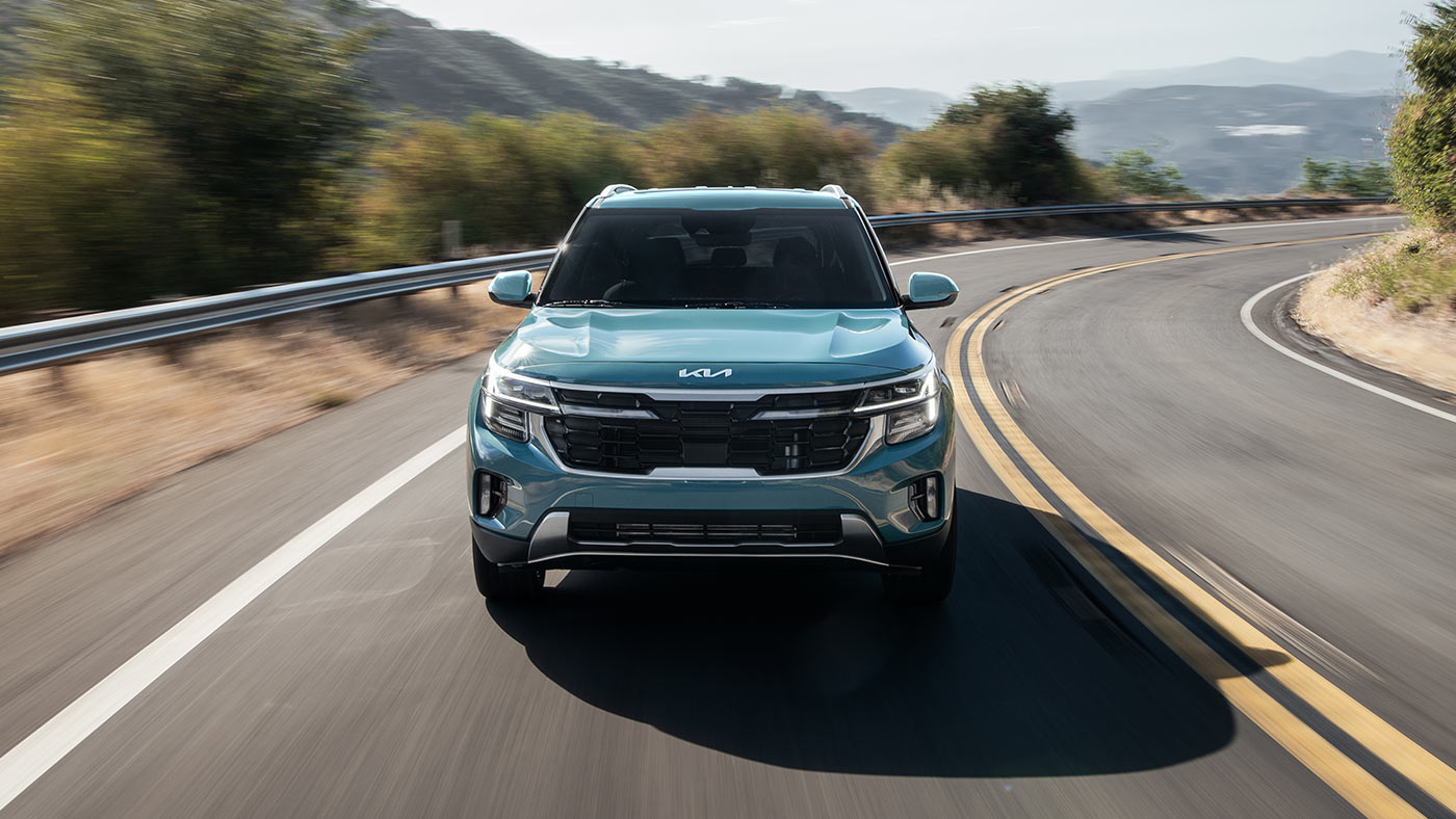 Un Kia Seltos de couleur Bleu Pluton roulant sur la route