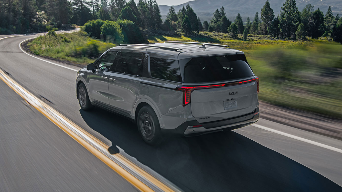 Vue de dos d’un Kia Carnival couleur Argent céramique avec deux feux arrière à DEL.