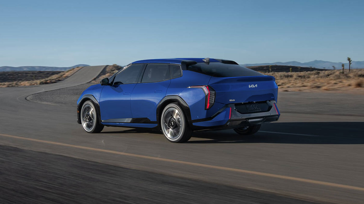 Blue Kia EV4 electric sedan driving on road