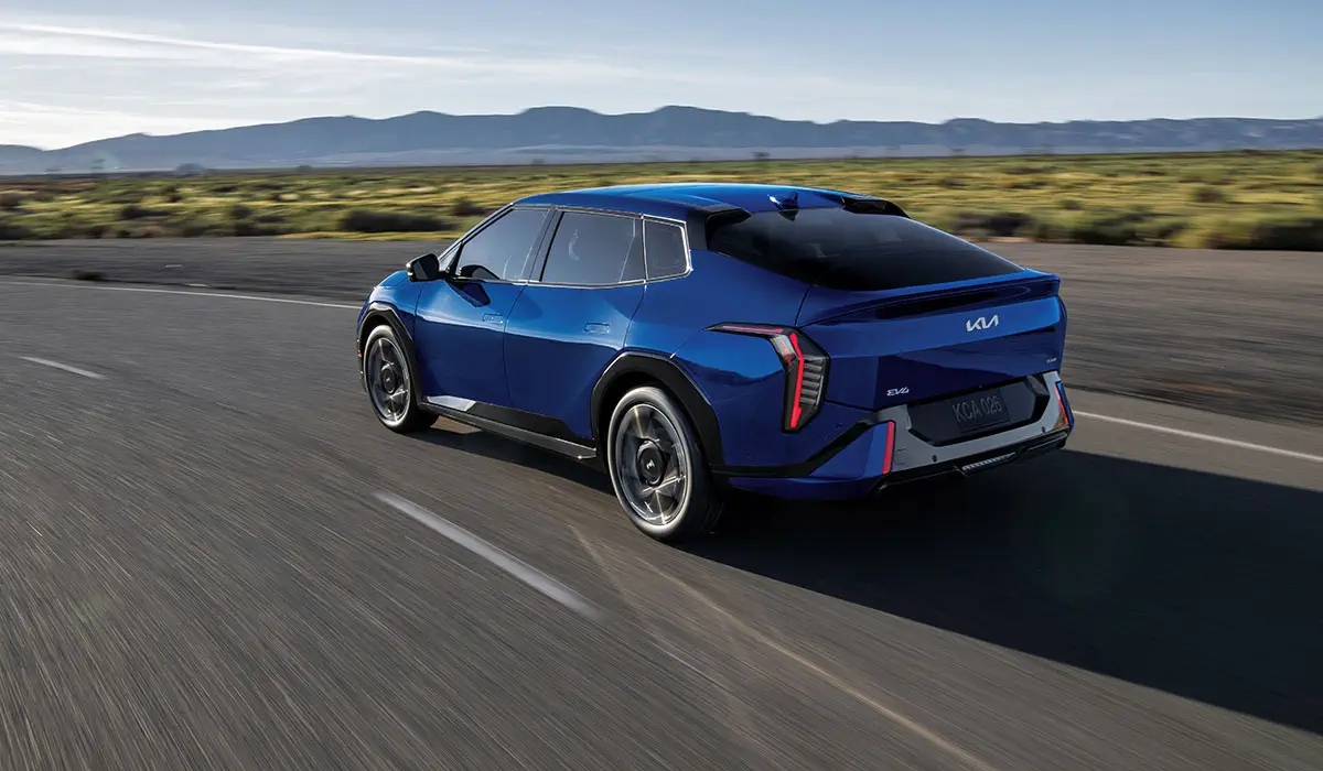 Blue Kia EV4 electric sedan driving on road