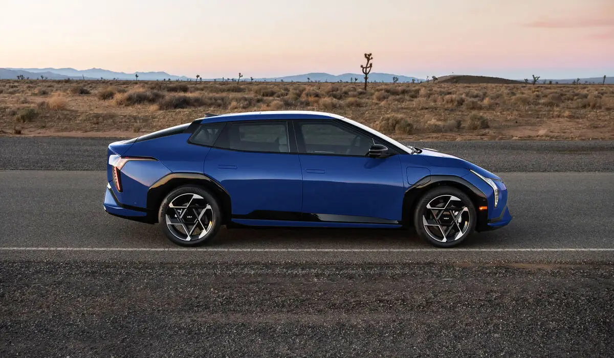Blue Kia EV4 electric sedan driving on road