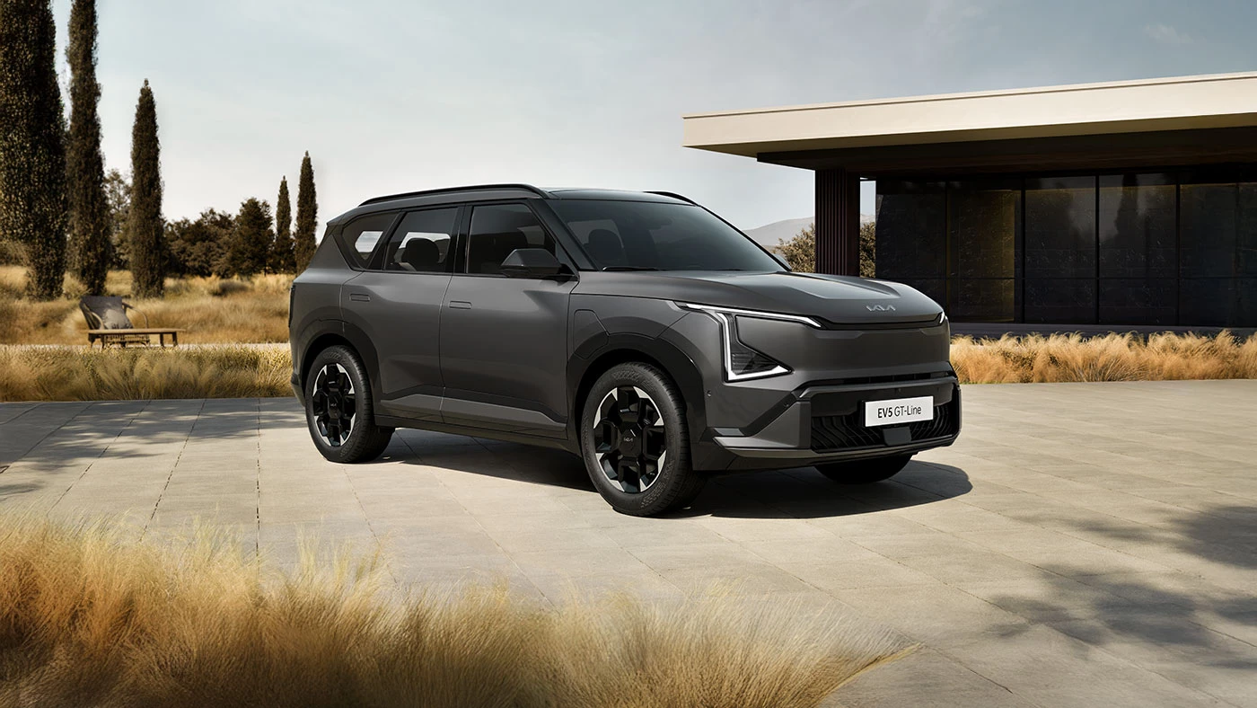 Grey Kia EV5 electric Compact SUV on road front 3/4 exterior